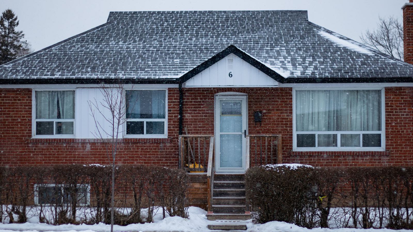 Maison en brique sous la neige, fenêtres blanches